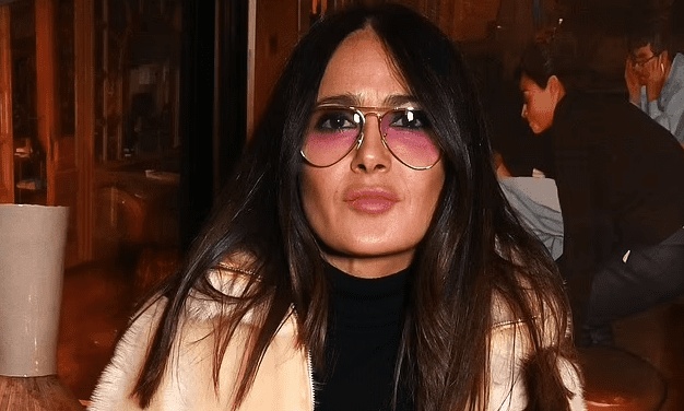 Salma Hayek cuts a stylish figure in retro-style glasses and a beige faux fur coat as she attends a Disney screening in Soho with filmmaker Alfonso Cuarón